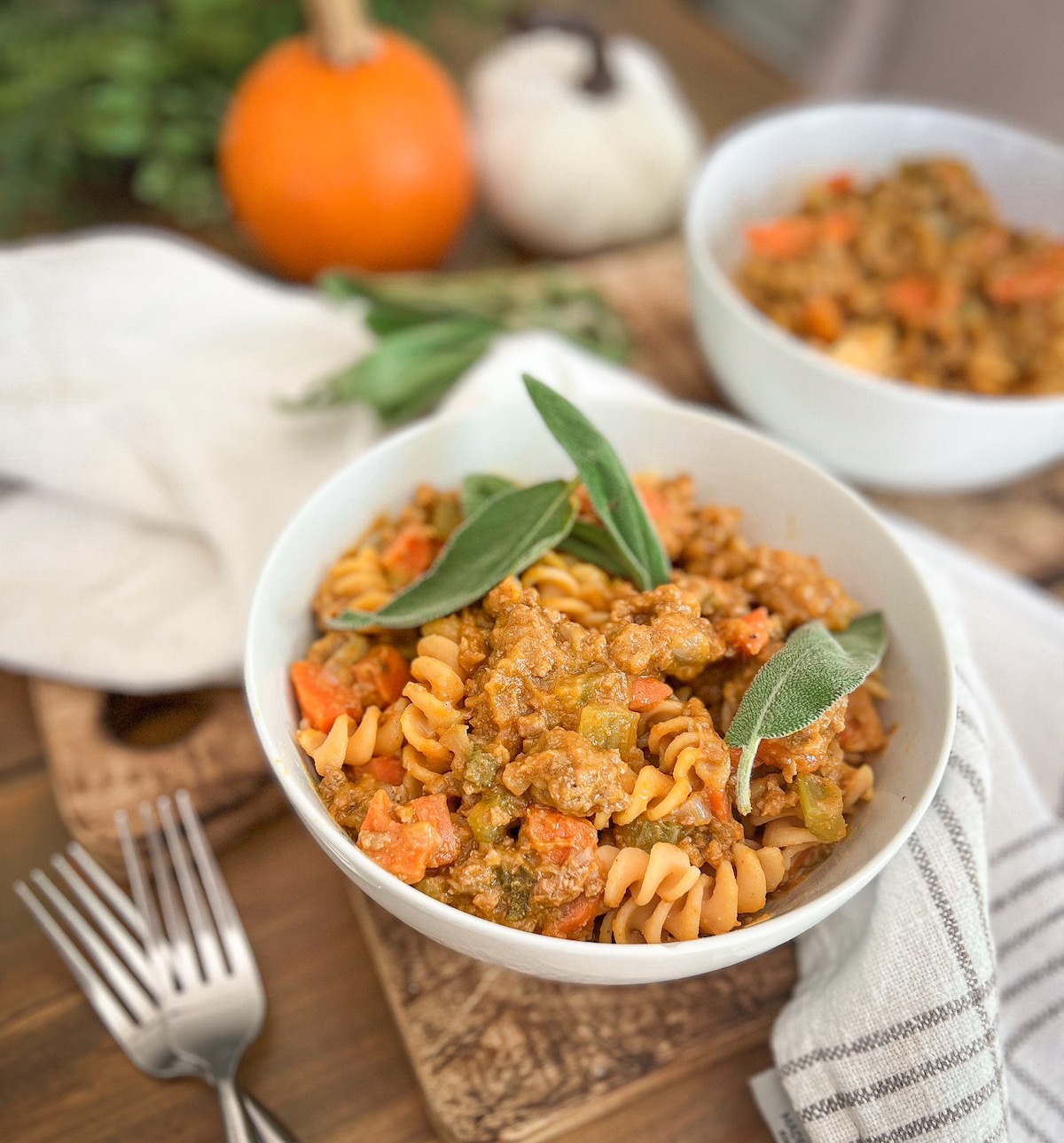 pumpkin bolognese in a bowl topped with fresh sage leaves