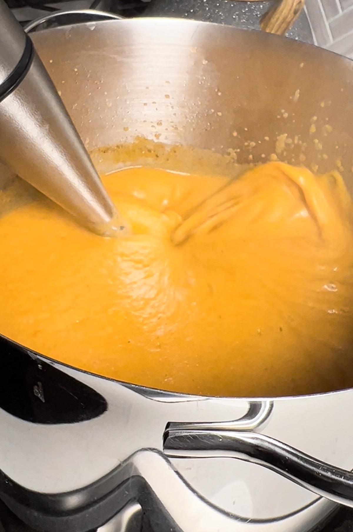 pureeing the soup with an immersion blender