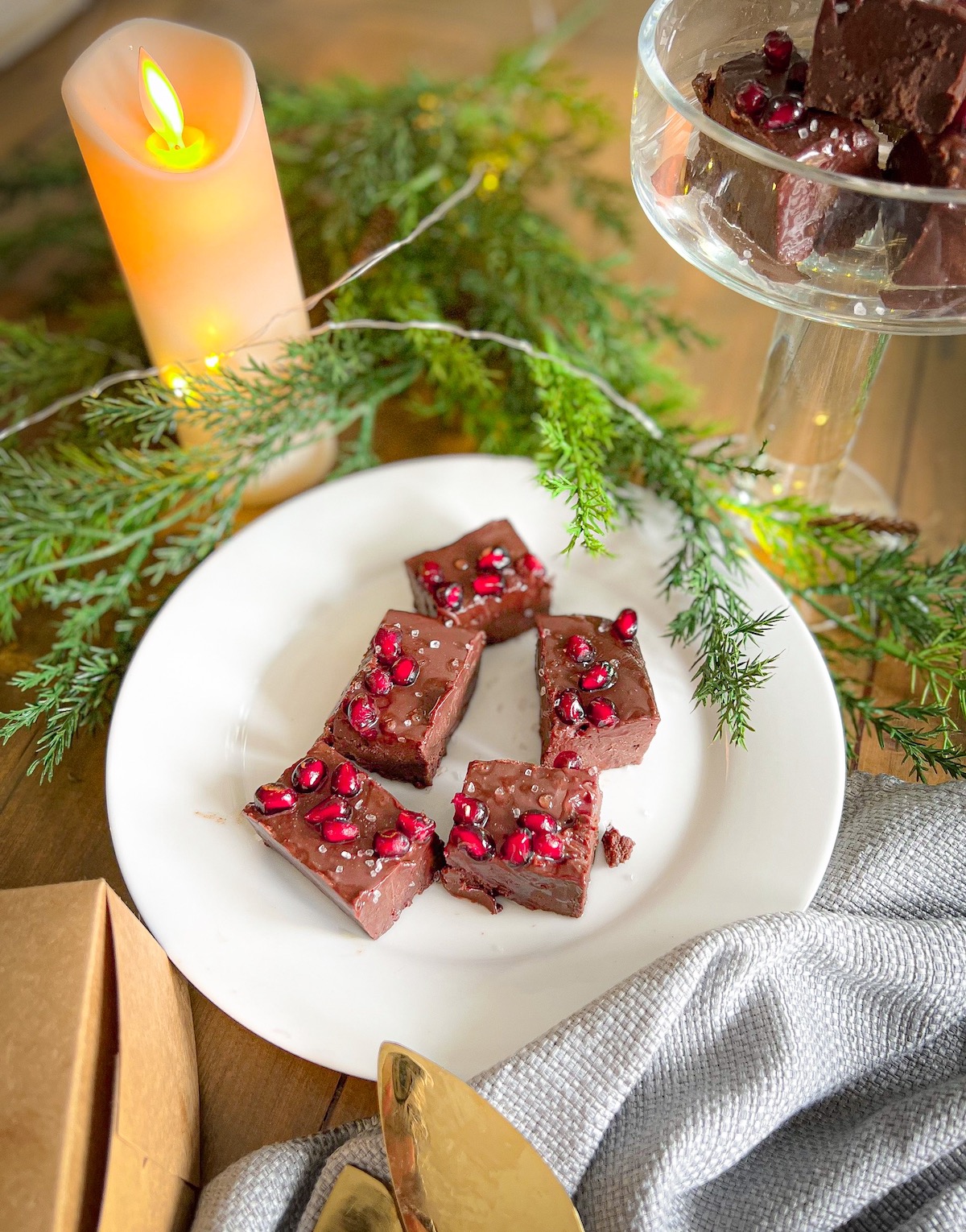 spiced holiday fudge on a white plate with holiday greenery
