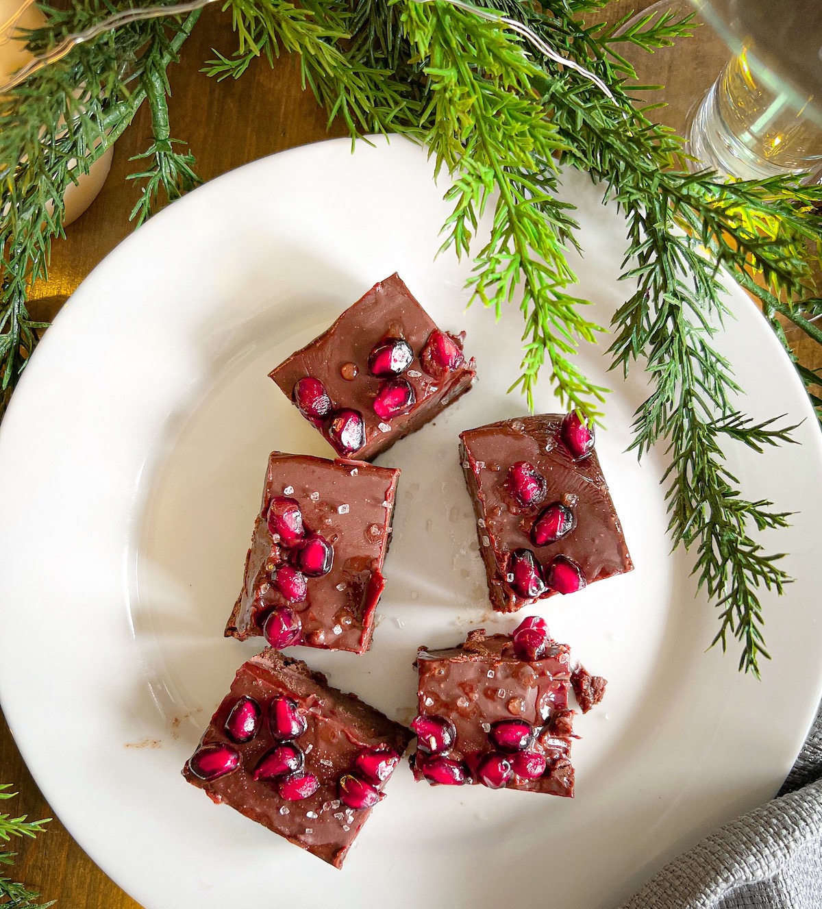 squares of spiced holiday fudge on a white plate with Christmas greenery