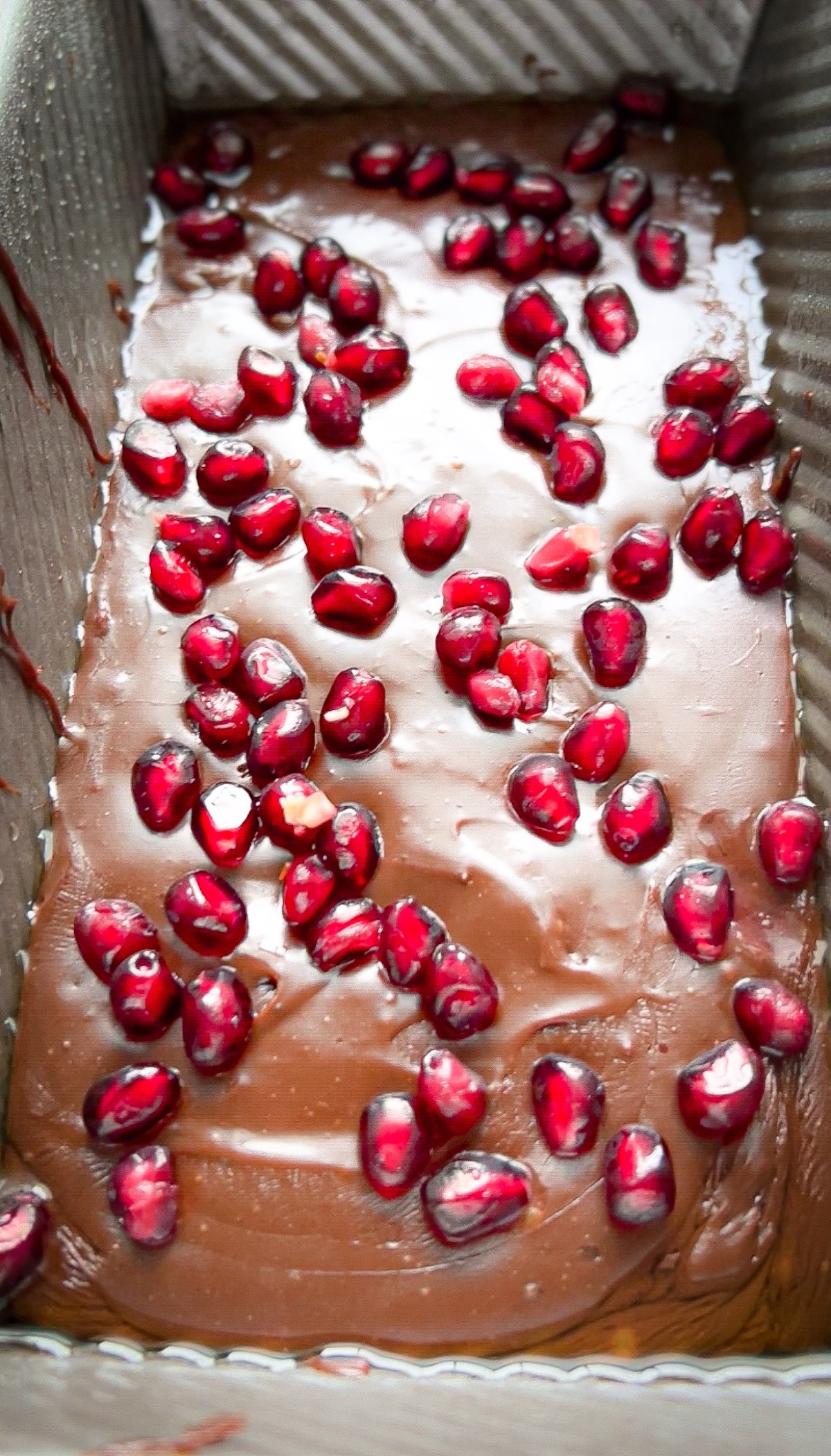 fudge poured into a greased loaf pan topped with fresh pomegranate seeds
