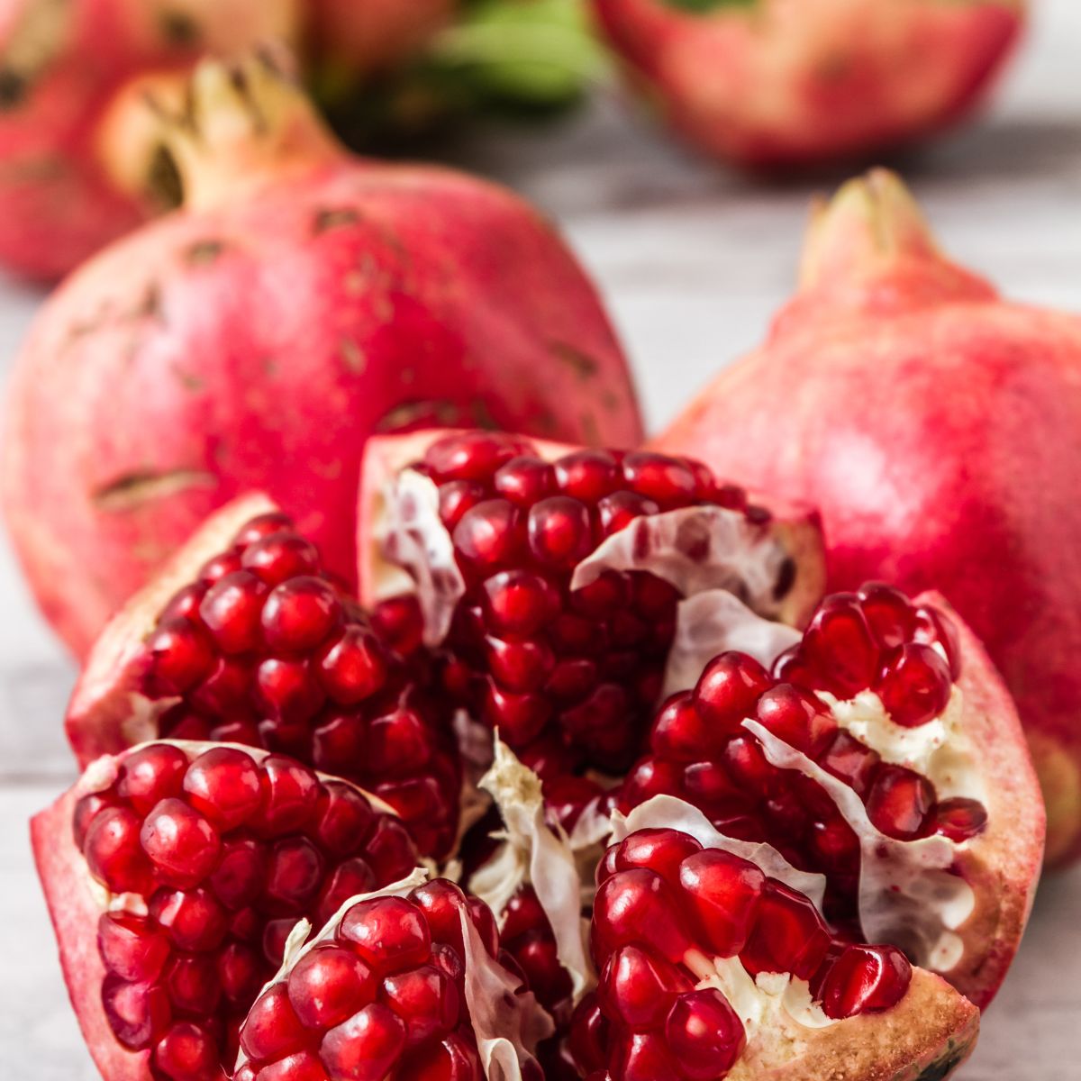 a pomegranate cut open showing seeds, with the chambers divided 