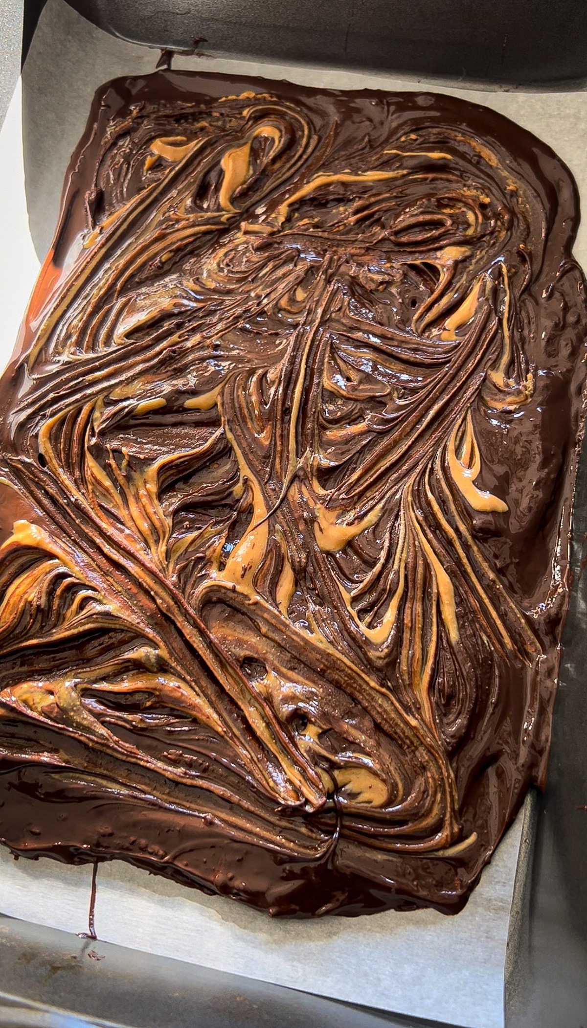 peanut butter swirled through melted chocolate in a marbled pattern